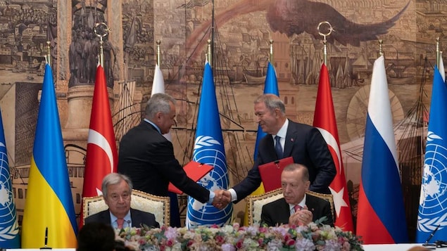 El presidente turco, Recep Tayyip Erdogan, a la derecha, y el secretario general de la ONU, Antonio Guterres, permanecen sentados mientras los representantes de Ucrania y Rusia se dan la mano durante una ceremonia de firma de un acuerdo para la exportación de granos en Estambul este viernes 22 de julio.