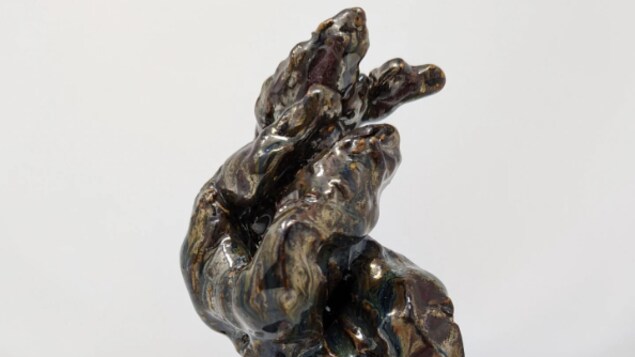 Une sculpture en céramique torsadée brune et reluisante qui rappelle un jet d'eau.