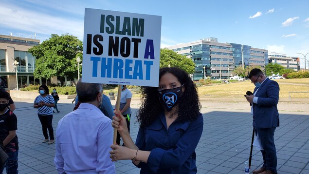 Una persona lleva un afiche que dice "El Islam no es una amenaza".