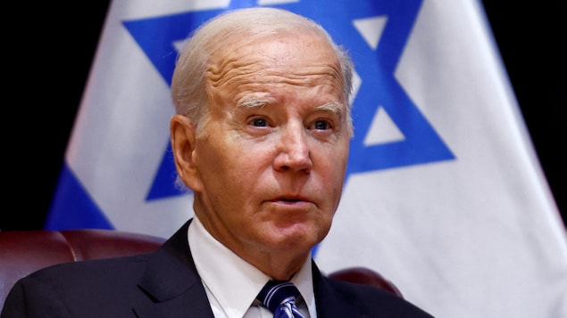 Joe Biden prend la parole avec derrière lui un drapeau d'Israël.