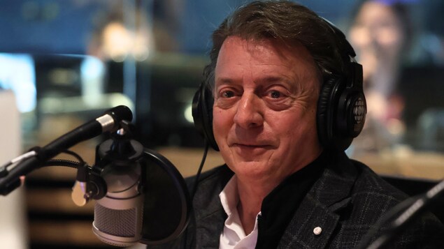 L'animateur Jean-Luc Mongrain devant un micro.