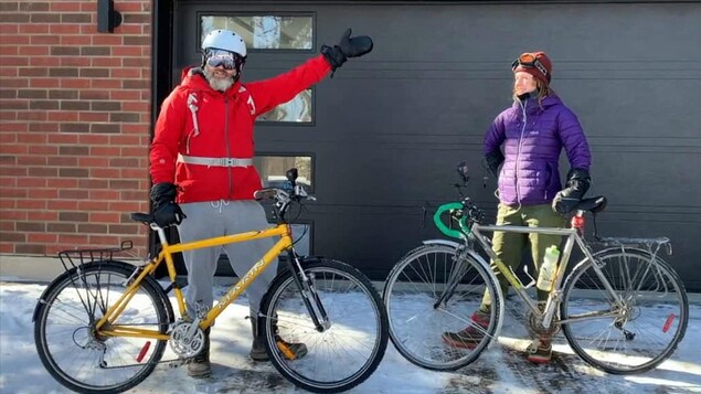 L'humoriste François Bellefeuille et sa collègue de travail devant une porte de garage avant leur départ en vélo.