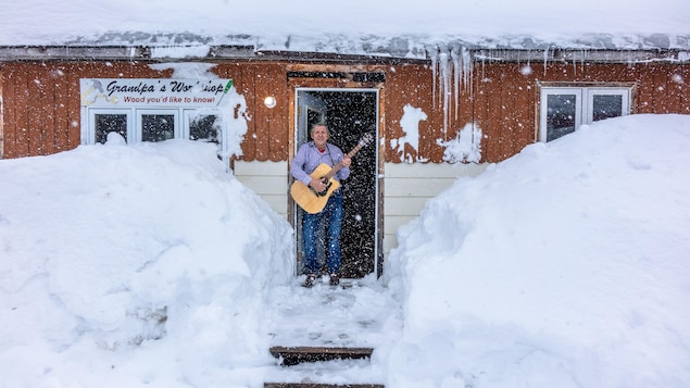 Le musicien Alister Martin tient une guitare dans sa main.