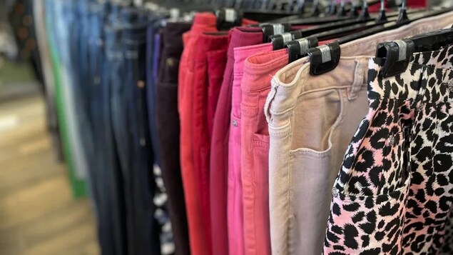 Des pantalons de toutes les couleurs sur des cintres.