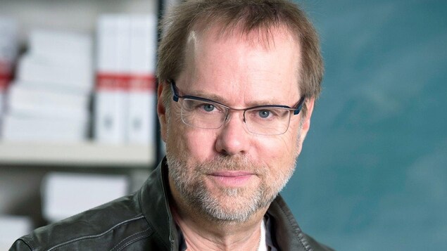 Denis Bouchard souriant à la caméra.