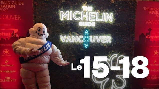 La mascotte Michelin près d'un écriteau néon.