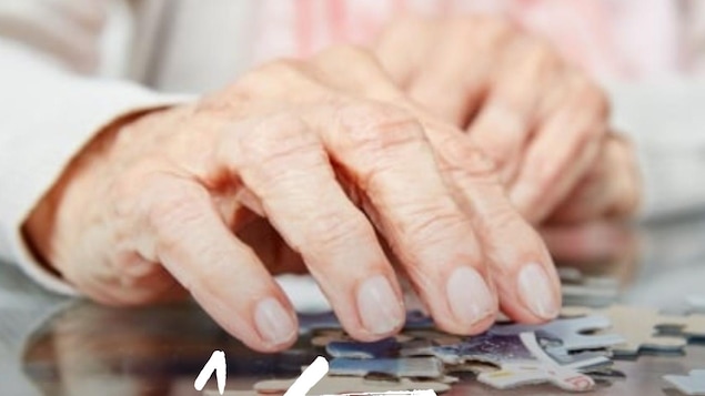 Gros plan sur les mains ridées d'une femme manipulant les pièces d'un casse-tête.