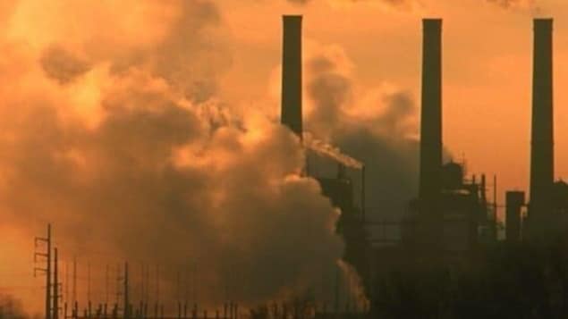Image montrant les cheminées d'une usine crachant beaucoup de fumée.