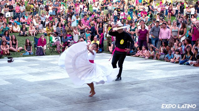 Deux personnes dansent devant une foule de gens,