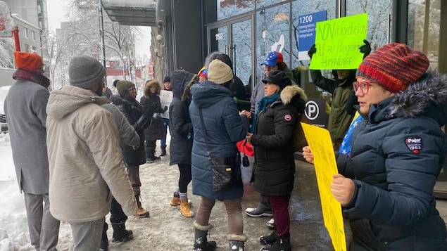 des personnes manifestant dans la neige et le froid, pancartes à la main