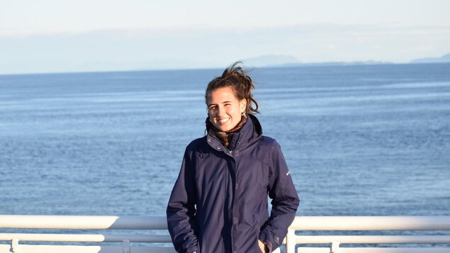 une femme en souriant a la caméra