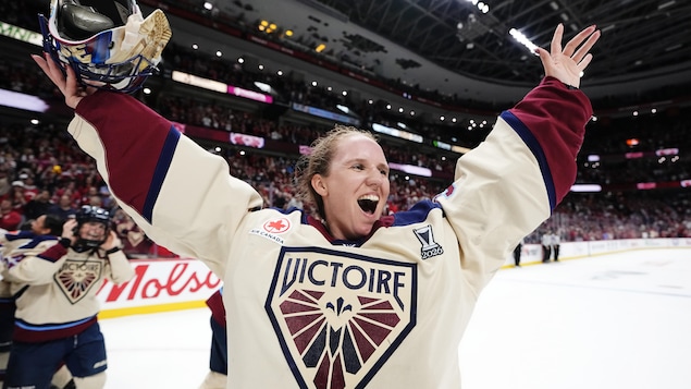 La gardienne de but Ann-Renée Desbiens retire son masque et célèbre une victoire de son équipe de hockey.