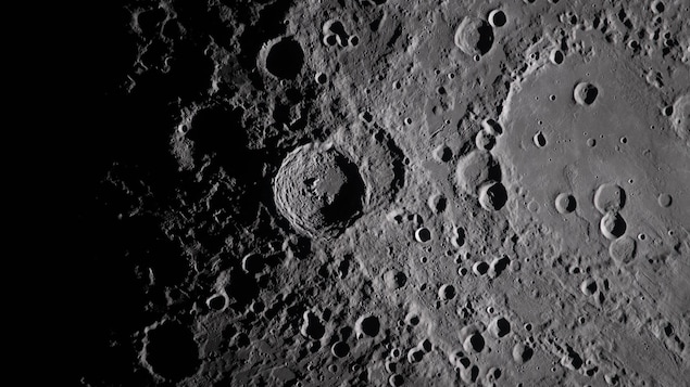 Des cratères, dont un immense, sur la surface de la Lune.