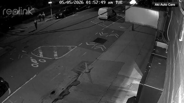 Une rue filmée par une caméra de surveillance. On y voit trois hommes en salopettes qui marchent vers une bouche d'égout. Des informations textuelles indiquent qu'il était 1 h 57 le 5 mai 2026.