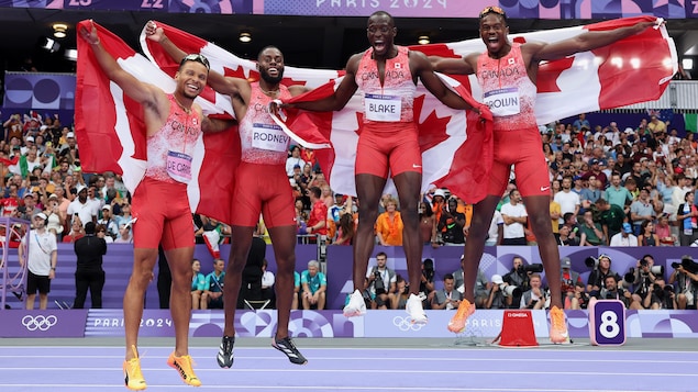 Jerome Blake, Aaron Brown, Andre De Grasse y Brendon Rodney celebran con la bandera de Canada.