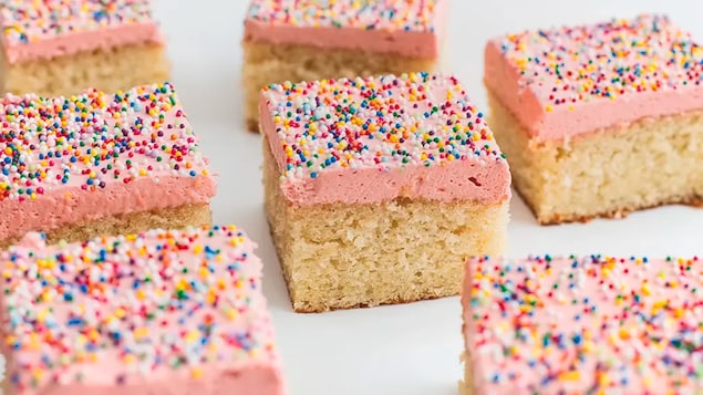 des parts de gâteau carrées couvertes de petits bonbons colorés.