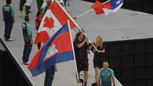 Ethan Katzberg y Summer Macintosh llevan la bandera canadiense.