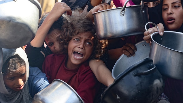 Una niña grita desesperada en medio de gente que agita cacerolas vacías.