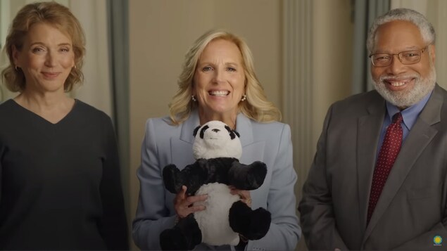 Deux femmes, un homme, et un panda en peluche.