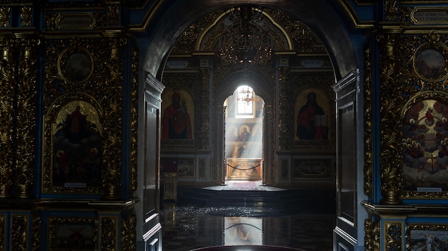 De la lumière s'infiltre dans une église dont le sol est inondé.
