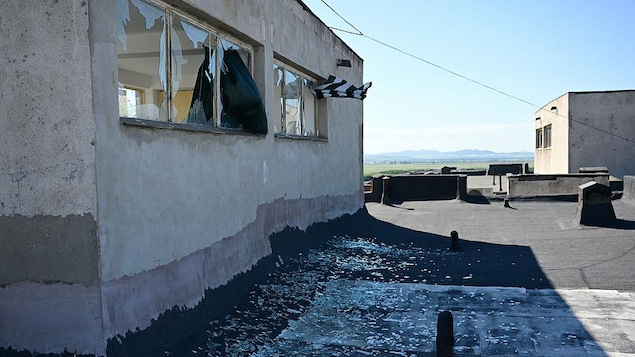 Sur le toit d'un immeuble, des fenêtres fracassées par une explosion.
