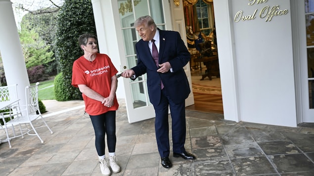 Devant la porte extérieure du bureau ovale de la Maison-Blanche, Donald Trump remet un billet de banque è une femme venue lui livrer un repas.