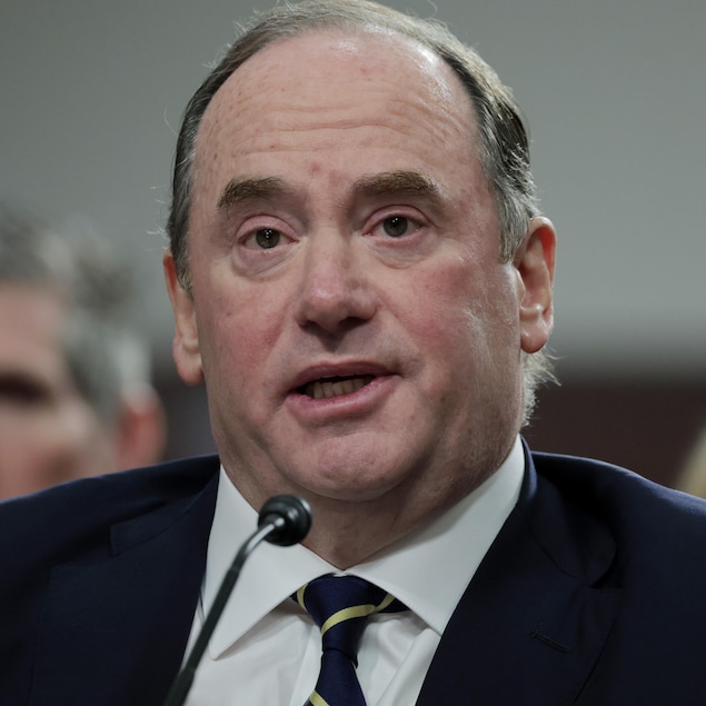 Gros plan de John Phelan qui parle dans un micro.