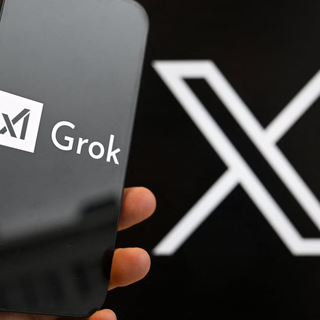 Le logo de Grok sur un téléphone et celui de X sur un écran en arrière-plan.