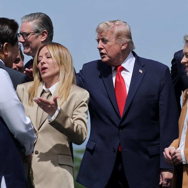 Donald Trump et Giorgia Meloni en discussion au milieu d'autres dirigeants.