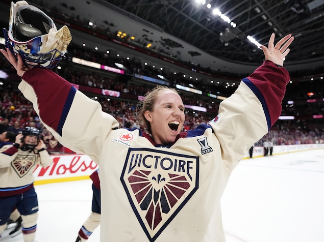 La gardienne de but Ann-Renée Desbiens retire son masque et célèbre une victoire de son équipe de hockey.