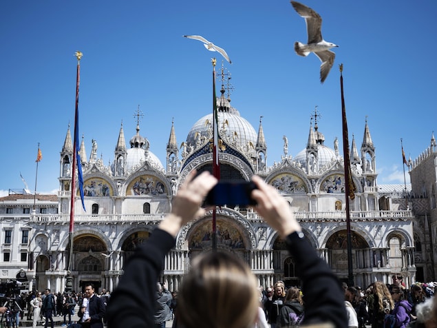 Une personne prend en photo la Basilique Saint-Marc à Venise, le 25 avril 2024.