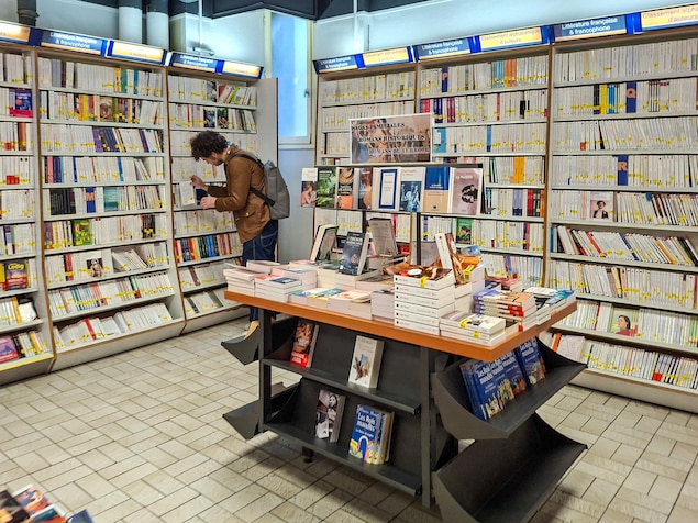Un homme regarde des livres dans une librairie.