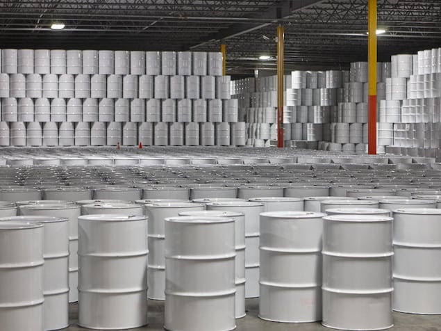 Des centaines de barils de sirop d'érable entassés dans un entrepôt.