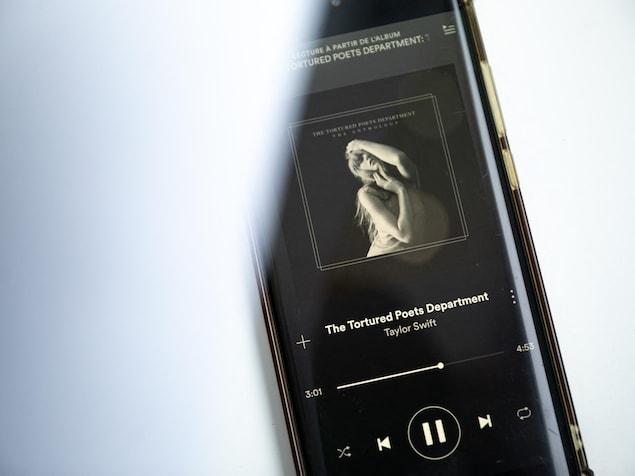 Une téléphone montrant la lecture de l'album The Tortured Poets Department de Taylor Swift sur Spotify.