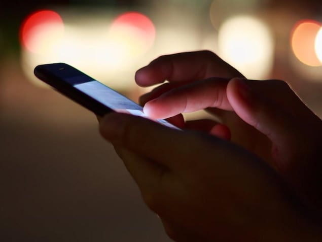 Gros plan sur les mains d'une personne manipulant un téléphone intelligent.