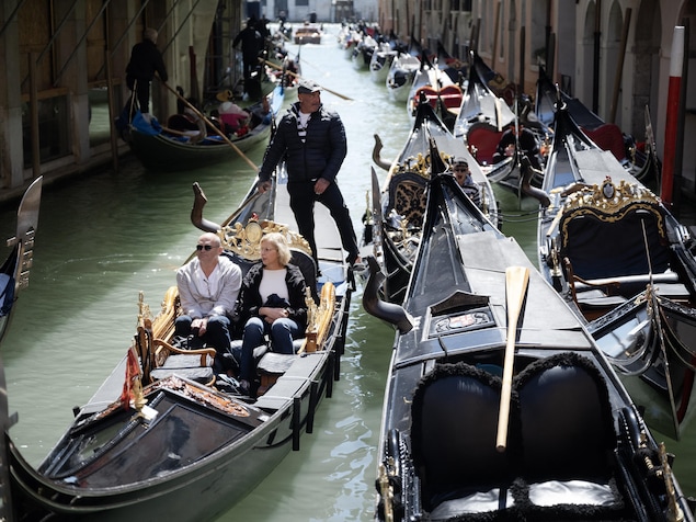 Des touristes sur des gondoles à Venise.