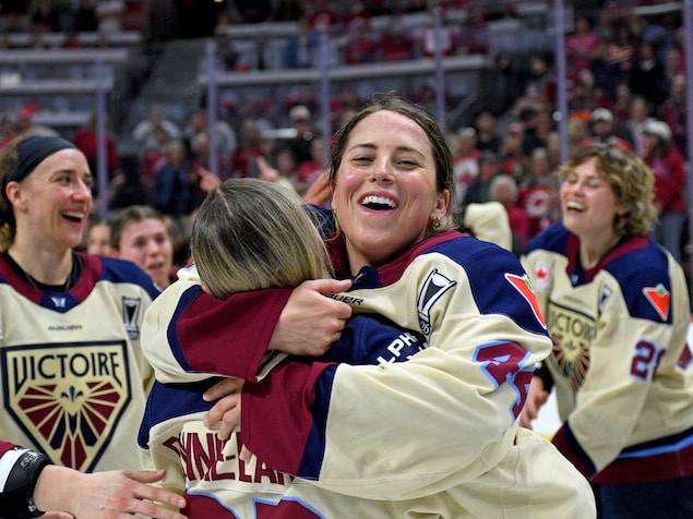 Les joueuses Amanda Boulier et Jade Downie-Landry s'enlacent après une victoire au hockey.