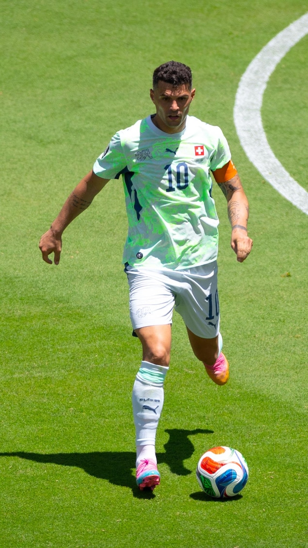 Un joueur s'apprête à botter un ballon lors d'un match de soccer.