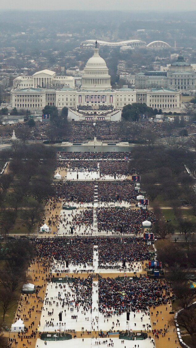 Une foule assiste à la cérémonie d'investiture de Donald Trump devant la Maison-Blanche, à Washington, mais à plusieurs endroits, la foule est parsemée.