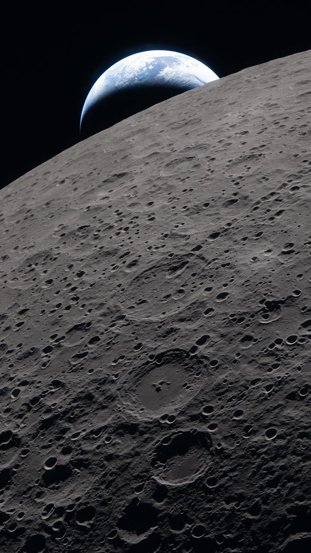 Un croissant de Terre derrière la surface de la Lune. 