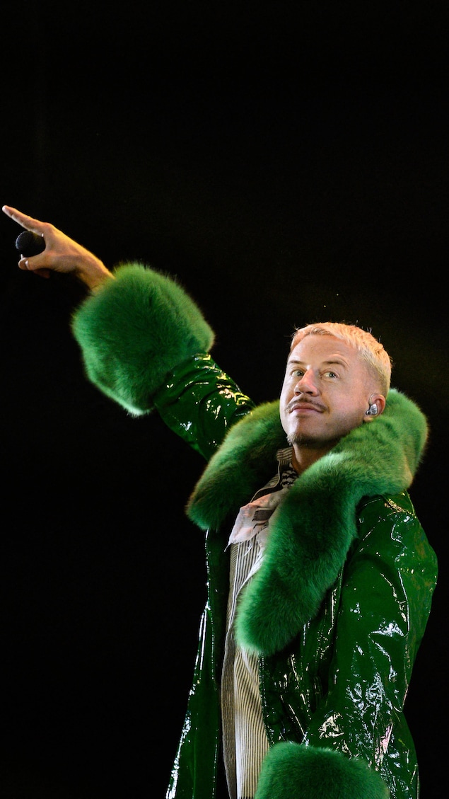 Le rappeur Macklemore, en concert, porte un manteau vert.