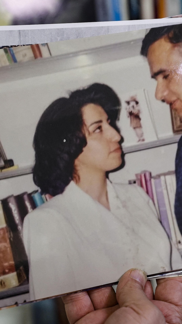 Une main masculine tient une photo montrant un couple, soit celui formé par Narges Mohammadi et Taghi Rahmani se regardant dans les yeux.