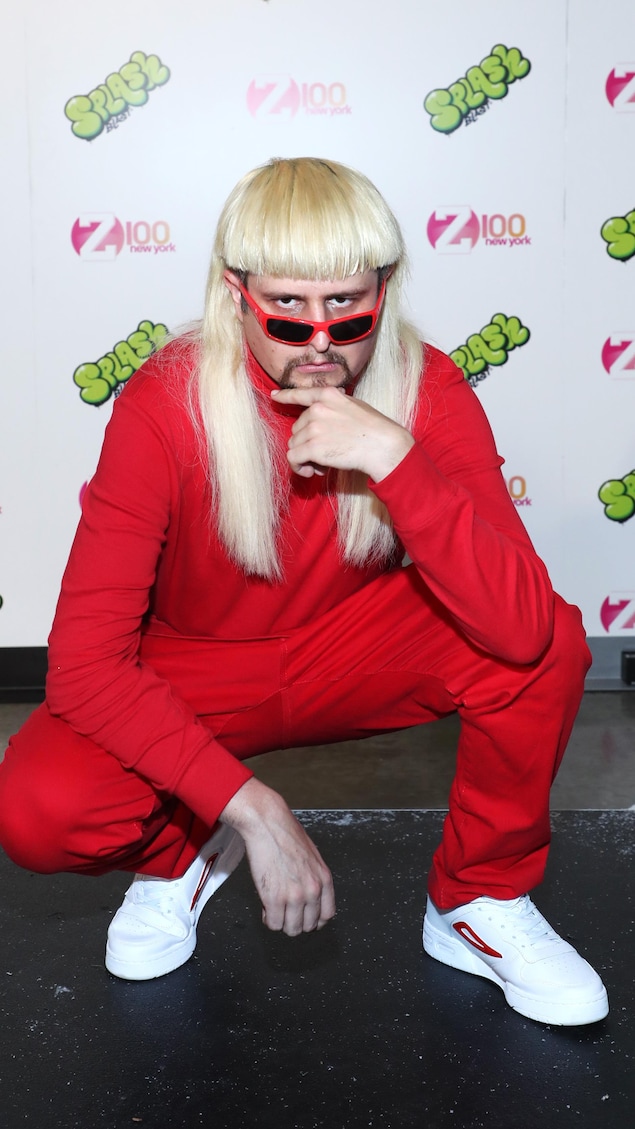Oliver Tree avec une perruque blonde et des vêtements rouges.