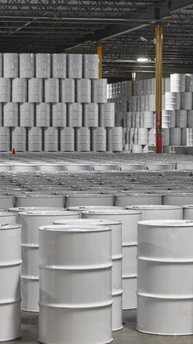 Des centaines de barils de sirop d'érable entassés dans un entrepôt.