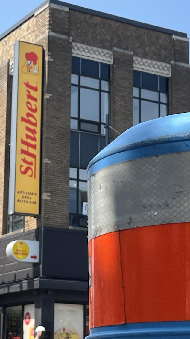 Un cône orange devant un restaurant St-Hubert.