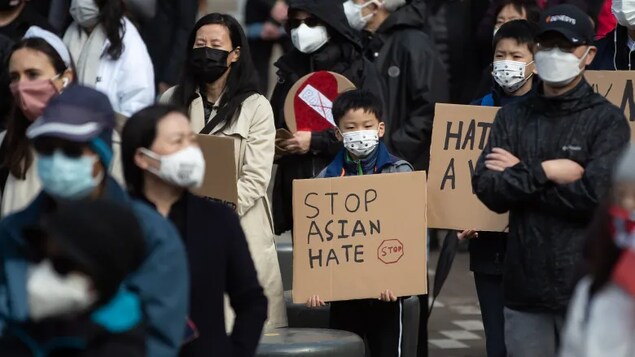 Mga taong nagpoprotesta na may hawak na placards na nagsasabing stop Asian hate.