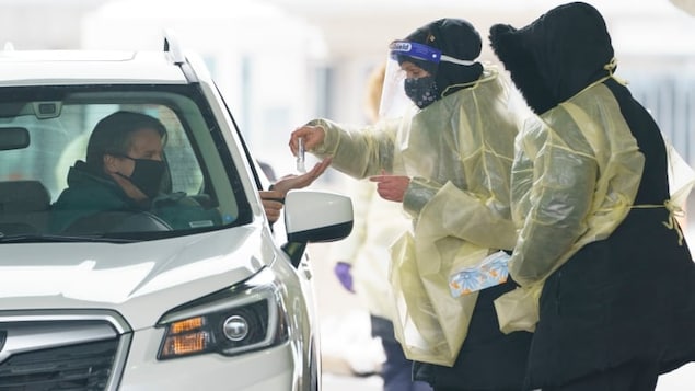 A passenger is screened and gets a COVID-19 test while entering Canada from the United States at the land border crossing in Saint-Bernard-de-Lacolle, Que., on Feb. 22, 2021.