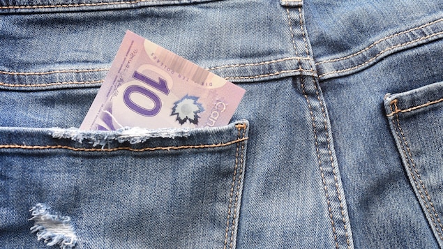 Un billet de 10 dollars canadiens dans la poche arrière d'un jean.