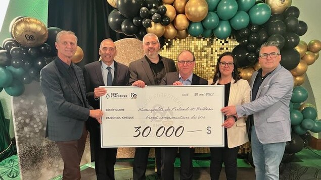 Des personnalités politiques tiennent un chèque de 30 000 $ entre leurs mains.
