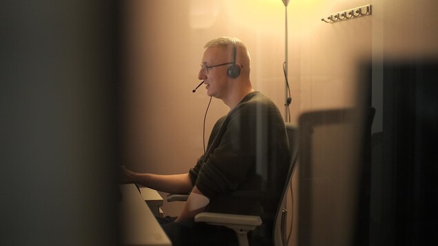 Un opérateur téléphonique travaille assis à son bureau.